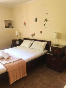 a bedroom with a large bed with two night stands and two lamps at Traditional village house on Argolis for 6 persons in Kariá +18 photos