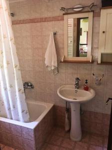 a bathroom with a sink and a shower curtain at Traditional village house on Argolis for 6 persons in Kariá