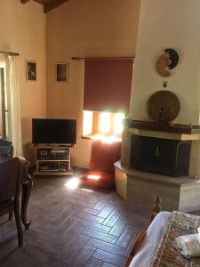 a living room with a fireplace and a television at Traditional village house on Argolis for 6 persons in Kariá