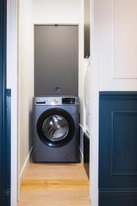 a washer and dryer in a hallway with a blue door at Sublime 3 Rooms Showers in Colombes