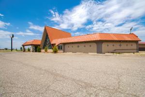 a building with an orange roof and a parking lot at American Best Inn By OYO I-35 Perry near Lake McMurtry in Perry