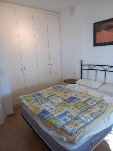 a bedroom with a bed with a quilt on it at Nautilus Agradable villa a 5 minutos a pie de la playa in Roses