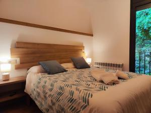 a bedroom with a large bed with a large window at Allotjaments el Pont in Camprodon