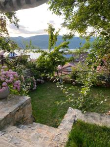 a garden with flowers and a view of the water at ROLEO Guest House in Lin