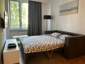 een slaapkamer met een bed, een bank en een raam bij K22 Large Apart Slawinska 509 in Warschau