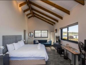 a bedroom with a large white bed and a desk at Southern most tip of Africa apartment with sea views in Agulhas