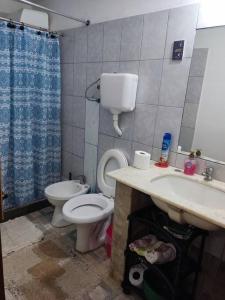 a bathroom with a toilet and a sink at Casa, para máximo 6 personas in Melo