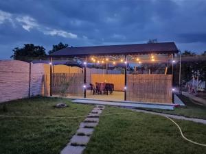 un cenador con una mesa en un patio por la noche en Camera de la Bunici - o poarta catre oriunde, 