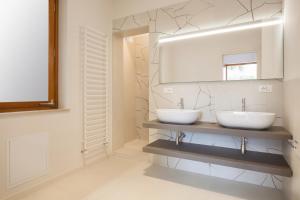 La salle de bains est pourvue de 2 lavabos et d'un miroir. dans l'établissement Villa Irene In Bardolino, à Bardolino