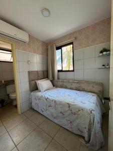 a small bedroom with a bed and a window at Apartamento Aquaville Resort in Aquiraz