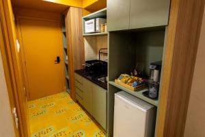 eine kleine Küche mit einem kleinen Kühlschrank in der Unterkunft Studio Savana in São Paulo