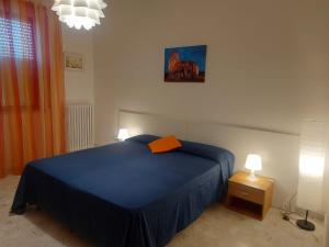 a bedroom with a blue bed and two lamps at Luciana's home in Lavello