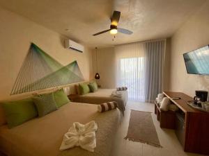 une chambre d'hôtel avec un lit et une télévision dans l'établissement sunsteps green falls, à Holbox