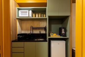 eine kleine Küche mit Spüle und Kühlschrank in der Unterkunft Studio Savana in São Paulo
