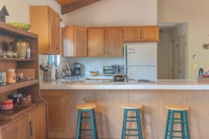 a kitchen with wooden cabinets and bar stools at Sweet Arnold Cabin in Arnold