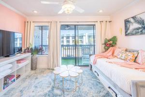 a living room with a couch and a tv at Palm Peach Tybee - Balcony - Oceanview "It's like, really pretty!" in Tybee Island