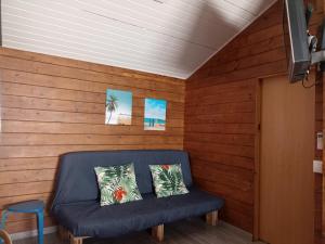 a blue couch in a room with wooden walls at La pinza bl am in El Palmar