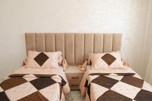 dwa łóżka siedzące obok siebie w sypialni w obiekcie Ayour appartement w mieście Azrou