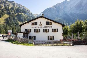 a building with a sign on it in front of a mountain at Miroir d'Argentine in Gryon