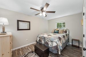 Un dormitorio con una cama y un ventilador de techo. en Coyote Cabin at Woodland Retreat at DeSoto beside DeSoto State Park, en Fort Payne