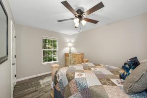 Un dormitorio con una cama y un ventilador de techo. en Coyote Cabin at Woodland Retreat at DeSoto beside DeSoto State Park, en Fort Payne
