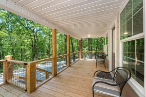 Un porche cubierto con dos bancos en una terraza de madera. en Coyote Cabin at Woodland Retreat at DeSoto beside DeSoto State Park, en Fort Payne
