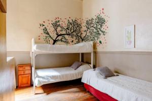 1 dormitorio con 2 literas y un mural en la pared en Dante y compañía en Buenos Aires