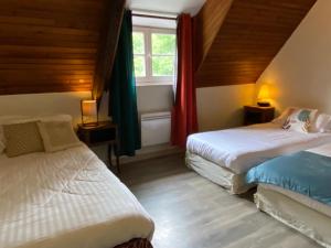 een slaapkamer met 2 bedden en een raam bij ÉCO-VILLAGE Les Moulins du Duc in Moëlan-sur-Mer