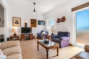 a living room with a couch and chairs and a tv at Tavira Balsa Romana - Luz de Tavira in Luz de Tavira