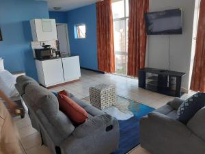a living room with two couches and a tv at Unit 95 Oceanic - Self Catering, North Beach in Durban