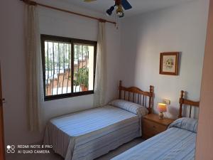 2 aparte bedden in een slaapkamer met een raam bij Villa Chalet Riomar Playa Oliva in Oliva