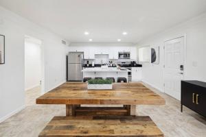 a white kitchen with a wooden table in the middle at Home 8 Minutes to Old Town Scottsdale in Scottsdale