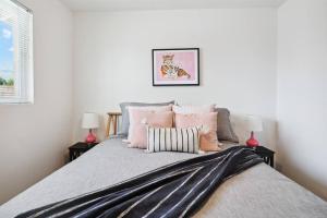 a bedroom with a large bed with pink pillows at Home 8 Minutes to Old Town Scottsdale in Scottsdale