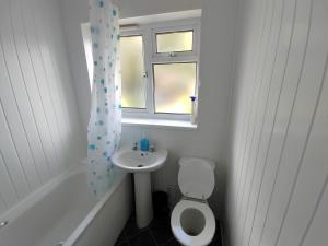 een badkamer met een wastafel, een toilet en een raam bij Browning House in Lincoln
