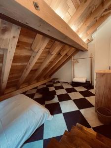 a attic room with a bed and a checkered floor at Sottotetto grazioso St.Moritz in St. Moritz