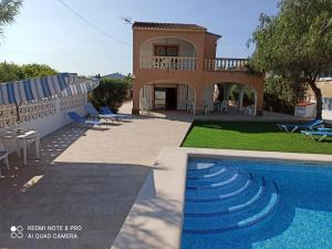 een villa met een zwembad en een huis bij Villa Chalet Riomar Playa Oliva in Oliva