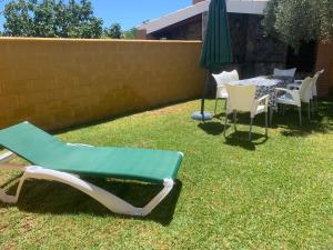 コニル・デ・ラ・フロンテーラにあるChalet Huerta del Sol Conilの椅子とテーブルと傘のある庭