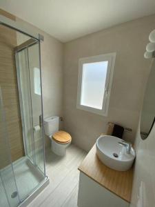 a bathroom with a shower and a toilet and a sink at Apartamento Villa Irene Menorca in Cala Santandria