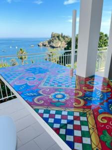 a mosaic floor on a balcony with the ocean in the background at Paradisea Taormina in Taormina