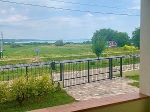 balkon z bramą i widokiem na drogę w obiekcie Pine&Chill Apartments w mieście Balatonalmádi