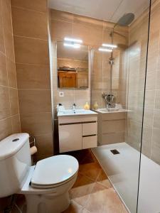 a bathroom with a toilet and a sink and a shower at Penthouse Casa Torre in Armação de Pêra