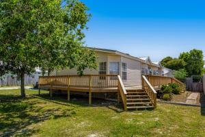 a mobile home with a large deck on a yard at Twin Lakes Cottage in Panama City Beach