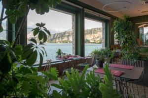 ein Restaurant mit Blick auf das Wasser in der Unterkunft Hotel Paradiso Conca d'Oro in Nago-Torbole