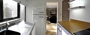 uma cozinha com um lavatório e um frigorífico em THE EDGE - Architect Designed - by Crown Gardens Holiday Homes em Brighton & Hove