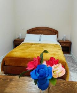 - une chambre avec un lit et un bouquet de fleurs dans l'établissement Araucaria, à Essaouira