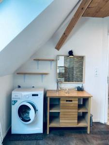a laundry room with a washing machine and a table at Studio à la ferme 