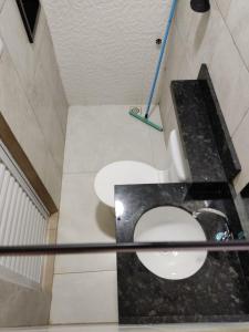 a bathroom with a white toilet in a room at Condomínio DINASEG in Rio Branco