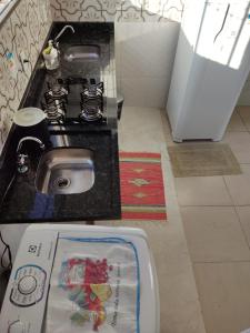 uma cozinha com um lavatório e um fogão num quarto em Condomínio DINASEG em Rio Branco