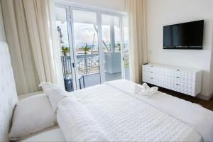 - une chambre avec un grand lit blanc et un balcon dans l'établissement LUXURY Villa en Puntarenas, Costa Rica, à Achiote