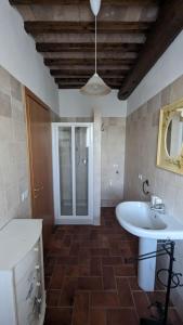 モンテプルチャーノにあるCasa Vacanze Il Faggioのバスルーム(白い洗面台、鏡付)